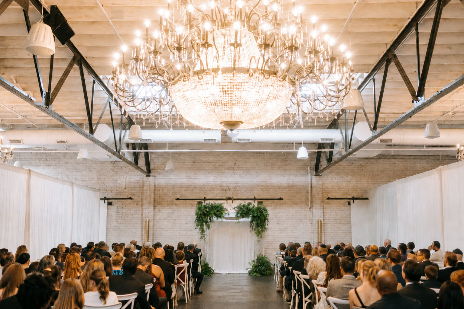 A full ceremony in a grand chandelier hall